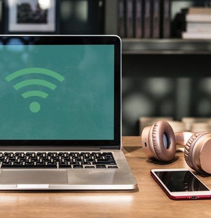 Laptop on desk with WiFi hotspot signal