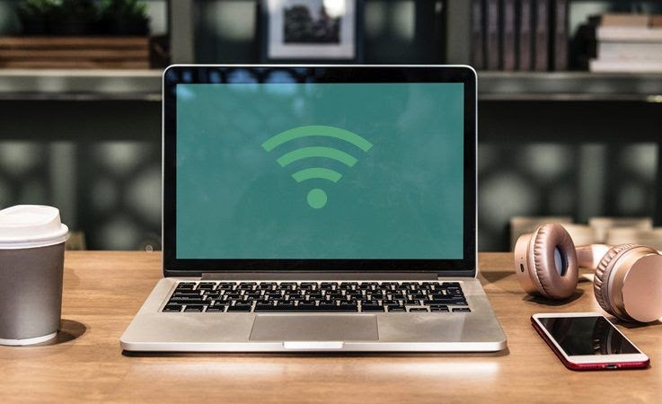 Laptop on desk with WiFi hotspot signal overlay